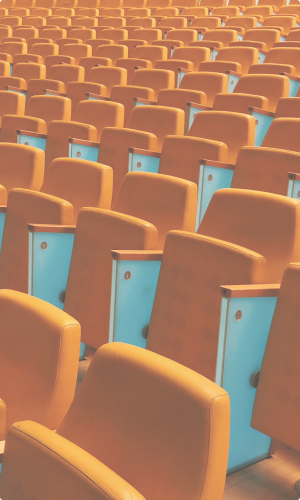 An auditorium of orange chairs
